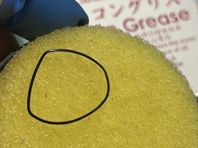 シリコングリース処理を施すために黄色いスポンジの上に置かれた黒いパッキン