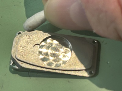 綿棒を使って金属製の腕時計の裏蓋周辺を細かくクリーニングする様子