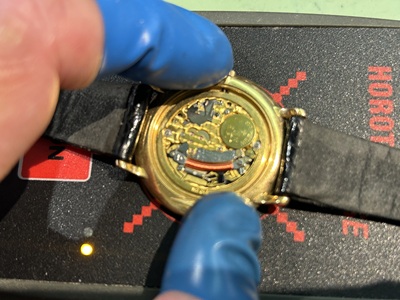 パルスチェッカーとルーペを使用して秒針のない腕時計の動作を確認する様子