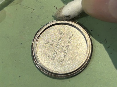 綿棒を使って腕時計の金属製裏蓋の内側やフチの汚れを取り除く工程