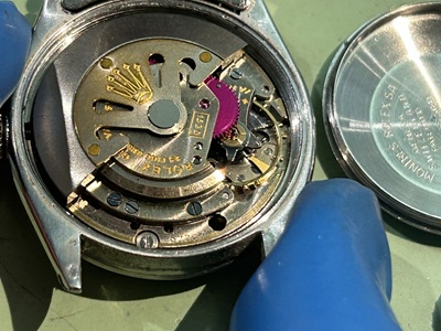 綿棒を使ってロレックスのケース周辺の微細な汚れやパッキンのカスを掃き出す清掃作業