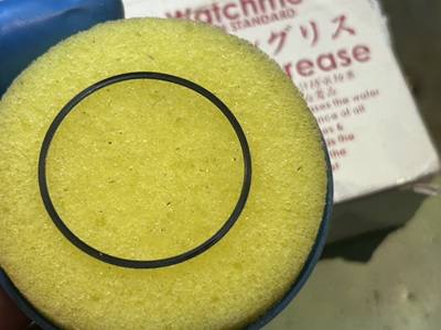 丸いゴムパッキンに専用の黄色いスポンジ器を用いてシリコングリースを塗布する様子