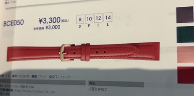 カタログに掲載された、ゴールド色の尾錠が付いた鮮やかな赤いレザーストラップ（ベルト）