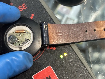 新しい電池をセットし、パルスチェッカーの上に載せて電気信号をテストしている様子