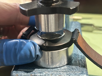 時計用の圧入機（プレス機）を使い、Knotの裏蓋に均等な力をかけて閉めている様子