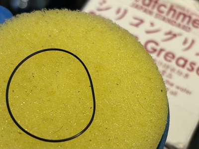 イエローのグリース器の上に乗せられたブラックのゴムパッキン