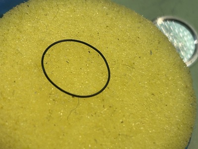 防水パッキン専用のシリコングリスを均一に馴染ませるための黄色い円形スポンジの上に置かれたパッキン