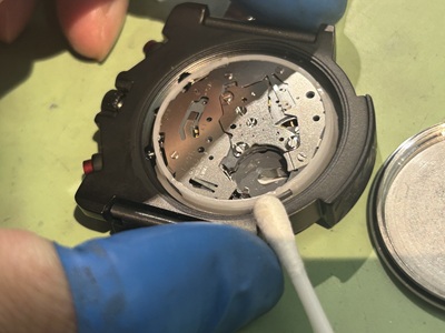 ケース内側の縁や受け部分を綿棒で優しく拭き取り清掃している様子