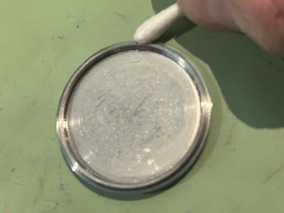 綿棒を使って裏蓋のフチや溝に付着した微細な汚れをお掃除している様子