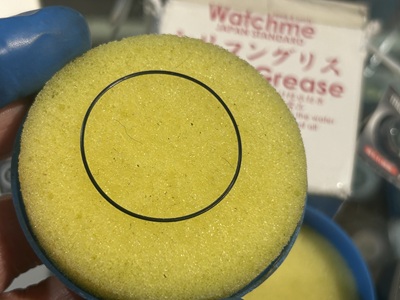 シリコングリース塗布用のイエロースポンジに挟んで馴染ませているパッキン