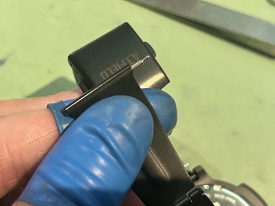 電池交換作業のために取り外していたベルトのバネピンを元の位置へ再取り付けしている様子