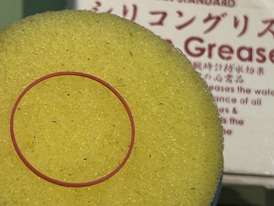 シリコングリース塗布器の上に置かれた赤いパッキン
