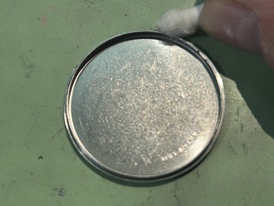 裏蓋のフチにある溝の汚れを綿棒で綺麗に拭き取っている様子