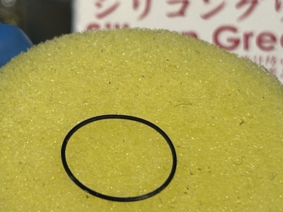 スポンジ状のグリース塗布器の上に載せられたシリコンパッキン