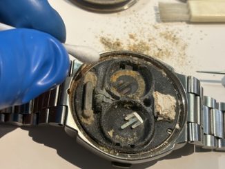 綿棒を使って基板・端子部分の精密清掃を行う作業の様子