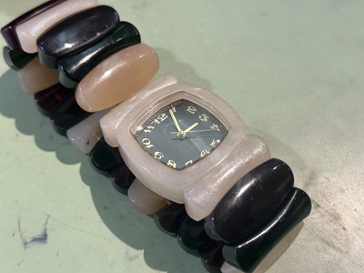 針が止まり、ブレスレットのゴムが伸びて隙間ができているTime Will Tellの腕時計