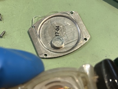 取り外されたボタン電池と、内部の汚れを清掃されたクォーツムーブメント