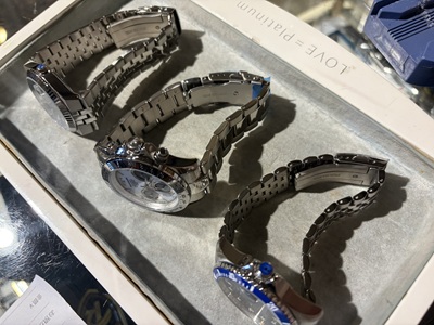 金属ブレスレットのベルト構造を確認している3本の腕時計