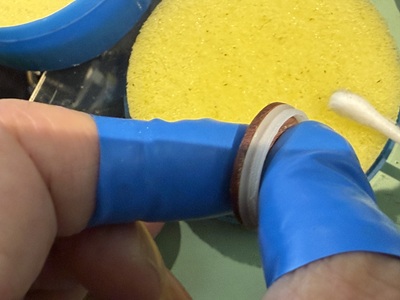 綿棒を使用して裏蓋パッキンの隙間にしっかりとグリースを馴染ませる作業