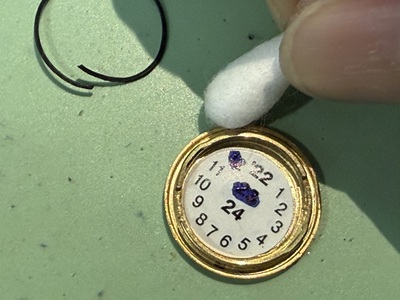 新しいパッキンを取り付ける前に裏蓋の溝を綿棒で掃除する様子