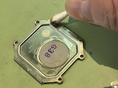綿棒を使って裏蓋の隅やネジ穴付近の皮脂汚れを拭き取る作業