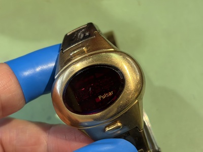青い指サックをつけた手で保持されたハミルトン パルサーの正面姿
