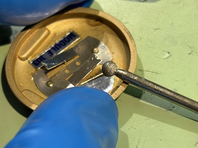 回転工具・ポイントを用いて裏蓋側の金属端子を磨く様子
