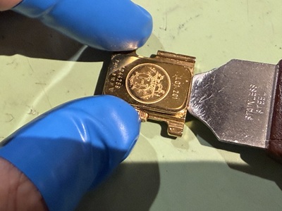こじ開け工具を裏蓋の隙間に差し込み開閉する様子