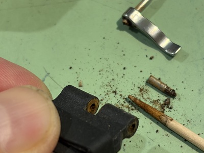 爪楊枝でラバーベルトの取付穴内部の錆を清掃する様子