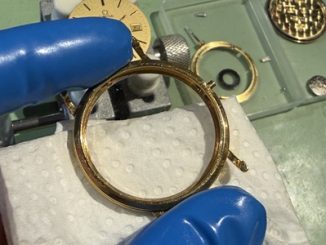 ケースとムーブメントを分離し、ケース内部を拭く職人の手