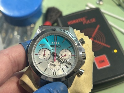 電池交換が完了し現時刻に合わせられたセイコー腕時計と背景のパルスチェッカー機器
