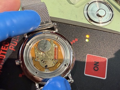 パルスチェッカーの上に置かれた時計本体と点灯するシグナルランプ