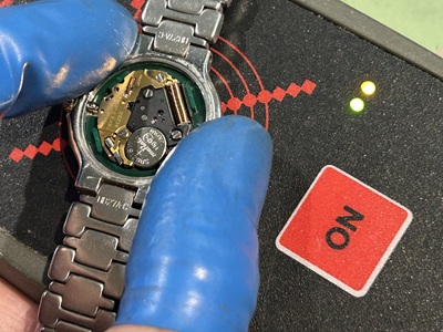 新しい電池を装着しパルスチェッカーで動作信号を測定している様子