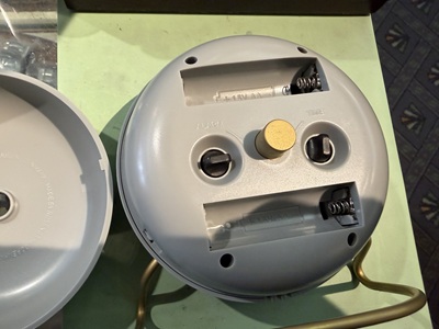 裏蓋が外され、電池ボックスと操作ノブが見える置き時計の背面構造