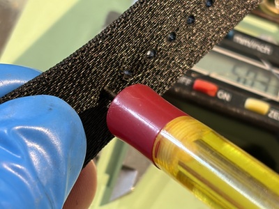印付け用の専用ペンでナイロン生地の表面に穴あけ用の印をつけている作業風景