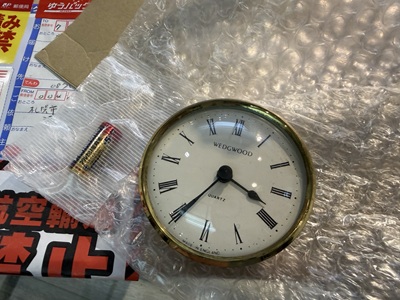 クッション材の上に置かれたウェッジウッドの時計と単5形乾電池