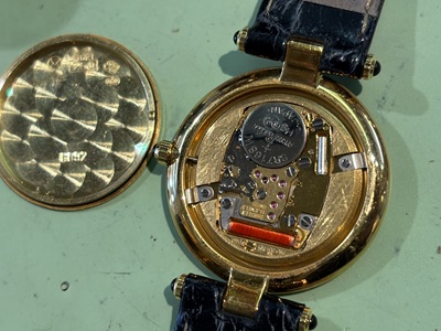 開けた裏蓋の横に置かれたピエールバルマンの金色ムーブメント