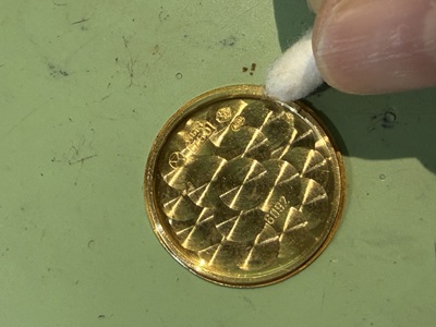 綿棒で18金裏蓋の縁や溝をきれいに拭き上げている様子